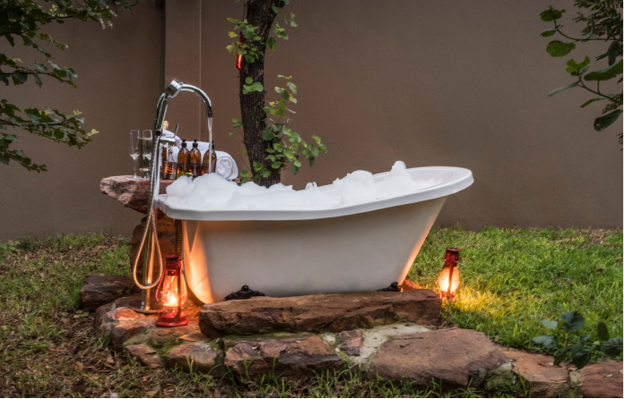 Invigorating outdoor bathtub in nature-filled Limpopo Game Lodge, a unique experience.