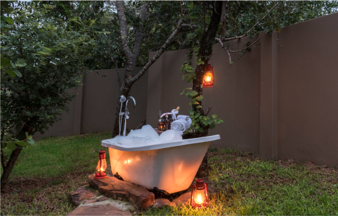 Luxurious open-air bathtub nestled in serene nature, epitome of outdoor relaxation.